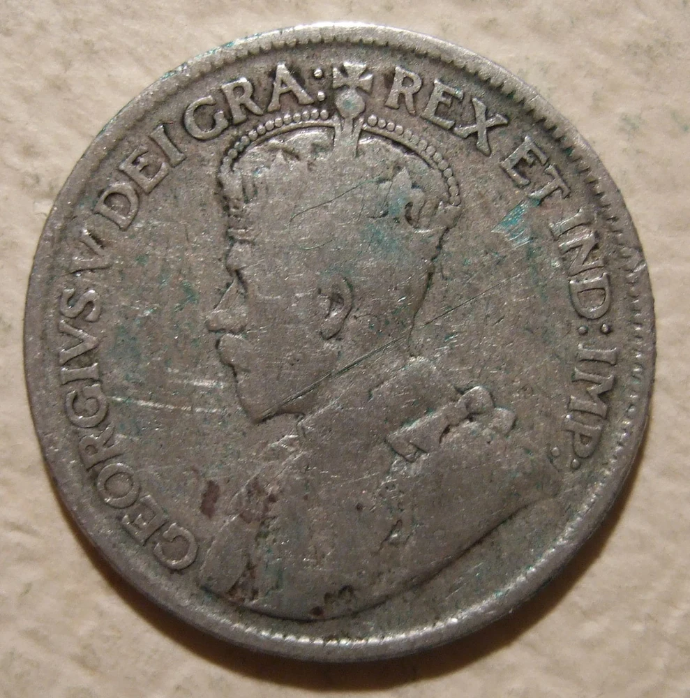 Canadian Quarter — 80% Silver obverse — 1936 Canadian twenty-five cents, George V portrait and denomination/maple wreath; Flickr license independently reviewed on Commons.