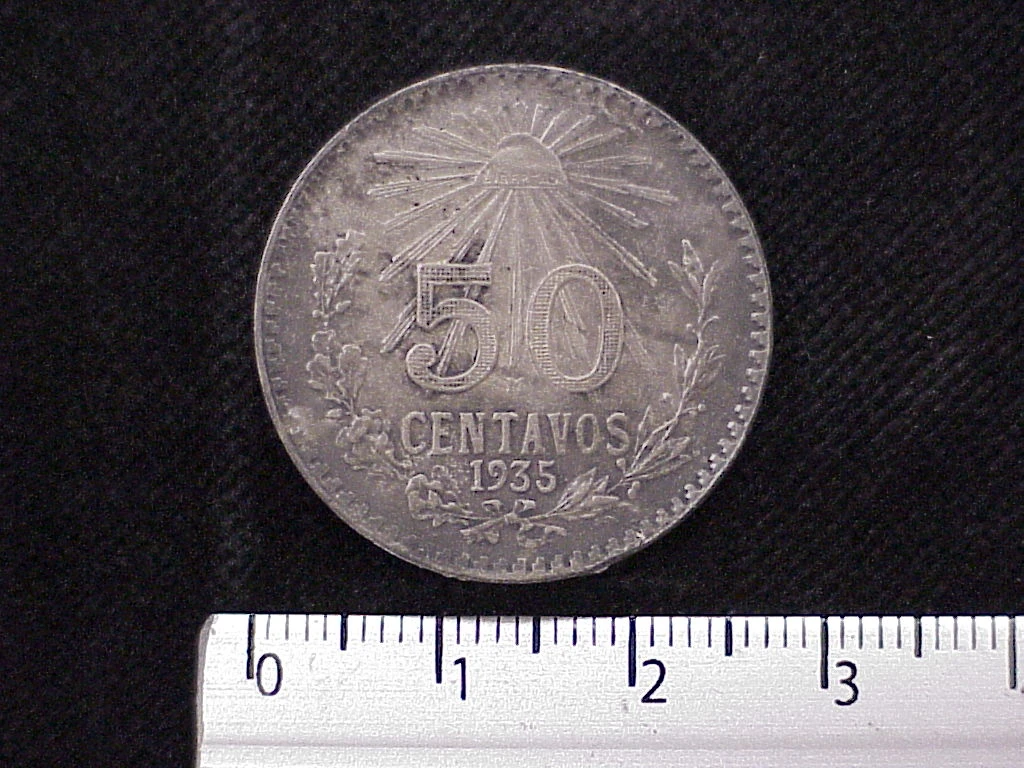 Reverse of a Mexican 1935 50 centavos silver coin showing a radiant Liberty cap, denomination and date.