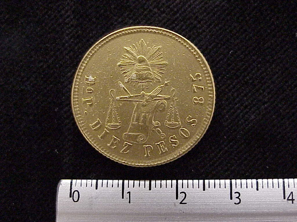 Reverse of a Mexican 1880 gold ten pesos coin showing a radiant Liberty cap, scales, denomination and .875 marking.