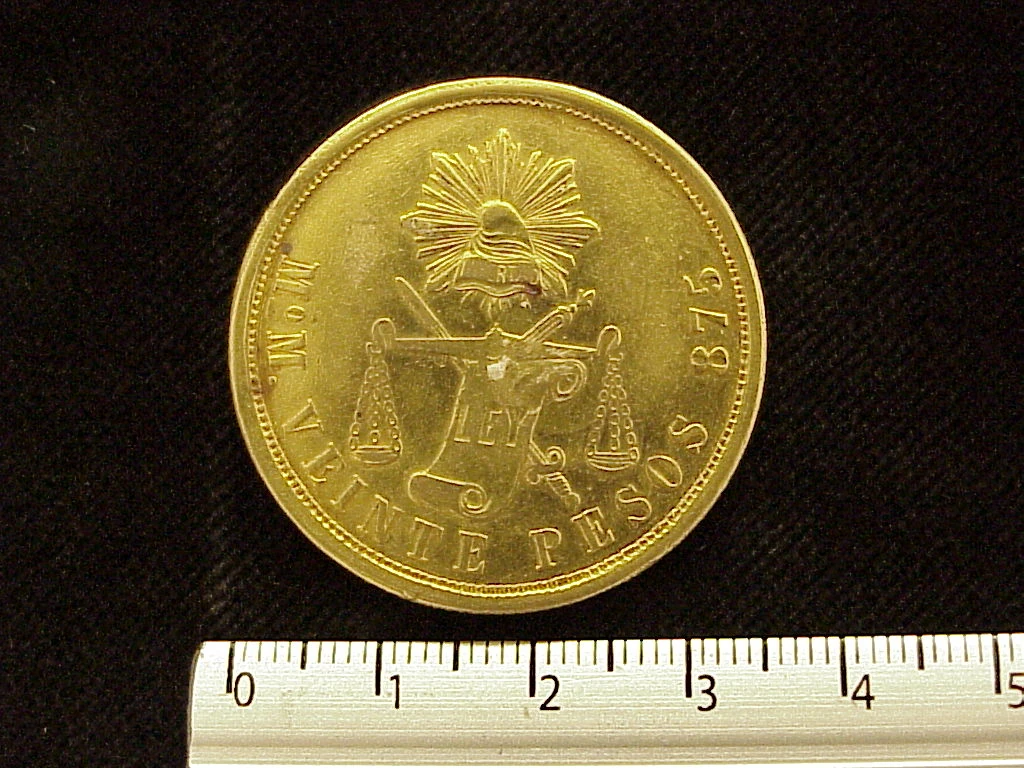 Reverse of a Mexican 1880 gold twenty pesos coin showing a radiant Liberty cap, scales, denomination and .875 marking.